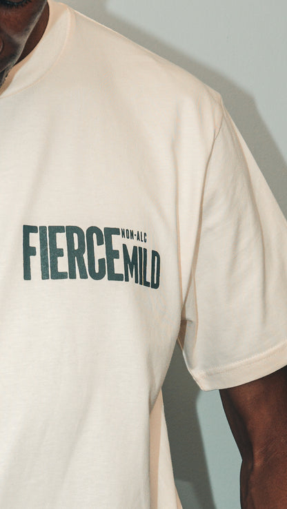 Model wears ecru Fierce Mild non-alc beer merchandise t-shirt. Image focuses on Fierce Mild logo located on top left of t-shirt, adjacent to the model's armpit.